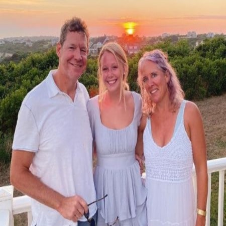 Miranda McKeon with her parents, posing for photographs with sunset wearing white dress